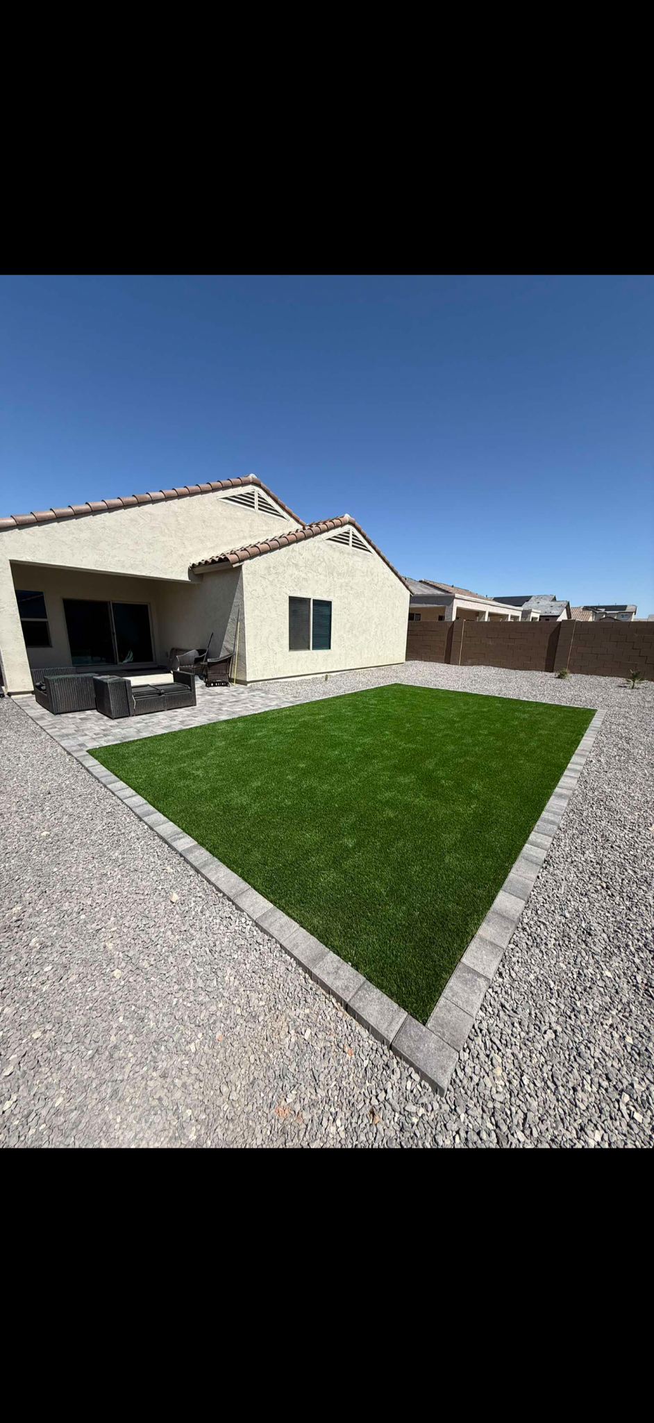 Artificial turf lawn with a clean paver border